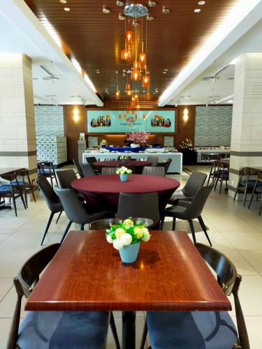 a dining room with two tables and chairs at Langkawi Seaview Hotel in Kuah
