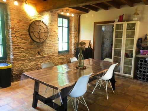 une salle à manger avec une table en bois et des chaises blanches dans l'établissement Chez Lucy&Nico, à Verfeil