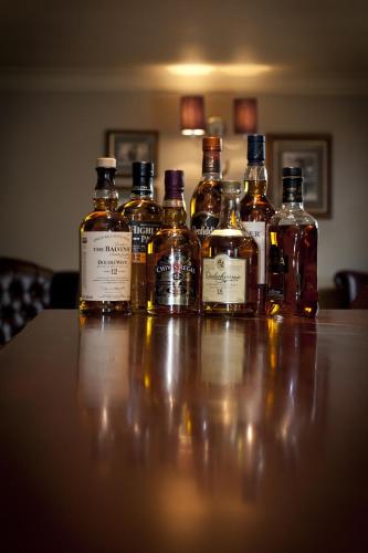 a group of bottles of whiskey sitting on a table at The Crown Inn in Stornoway