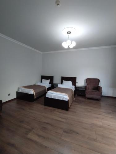 a room with two beds and a couch and a chair at Qusar Qala Hotel in Qusar