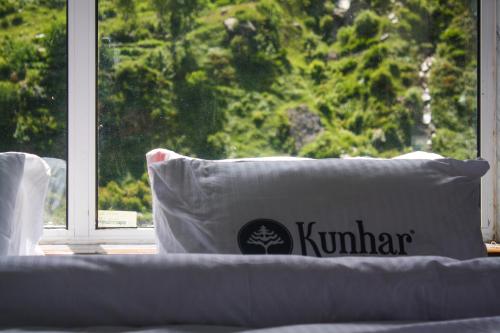 a white pillow sitting on a couch in front of a window at Kunhar Hotel RiverSide Block in Nārān