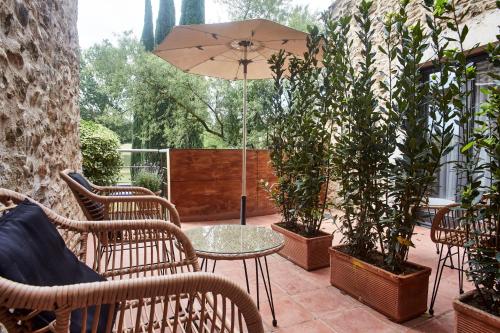 a patio with chairs and a table with an umbrella at Arcs De Monells - Adults Only in Monells