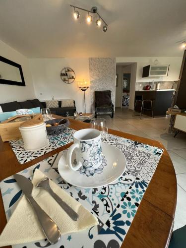 - un salon avec une table et une tasse de café dans l'établissement Appart Terre & Mer Deauville, à Bonneville-sur-Touques