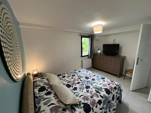 - une chambre avec un lit, une commode et une télévision dans l'établissement Appart Terre Mer Deauville, à Bonneville-sur-Touques