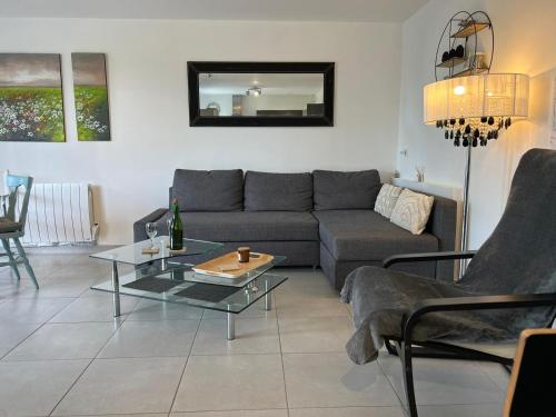 una sala de estar con un sofá y una mesa en Appart Terre & Mer Deauville, en Bonneville-sur-Touques