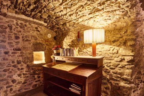 a table with a lamp on top of a stone wall at Arcs De Monells - Adults Only in Monells