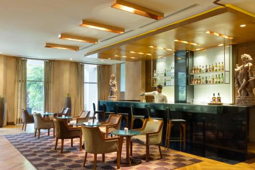 a bar at a hotel with tables and chairs at Trident Bhubaneswar in Bhubaneshwar