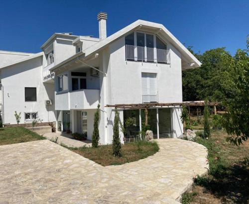 a white house with a porch and a driveway at SOHO B&B in Fisciano