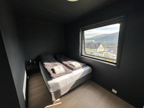 a small bedroom with a bed and a window at Remarkable 2-Bed Apartment in Tromso in Tromsø