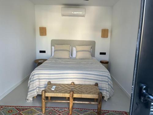 a small bedroom with a bed with a wooden table at CasaNoa Luxury Villa Bed and Breakfast in Jávea