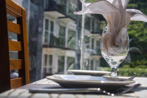 a table with a plate and a glass with a flower in it at Kunhar Hotel RiverSide Block in Nārān