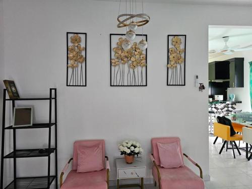 甘孟的住宿－Nafisa 3 Homestay，客厅配有两把椅子,墙上挂有图片