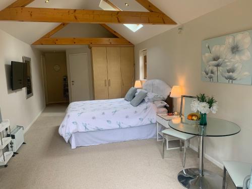 a bedroom with a large bed and a table at Old Ningwood Station in Shalfleet