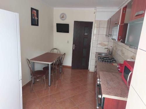 a kitchen with a table and chairs in a room at Eugenia Apartament in Ploieşti