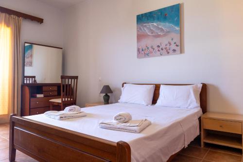 une chambre avec un lit avec des serviettes dessus dans l'établissement Venetico Beachfront Apartments & Suites - Sea View Studio, à Argassi