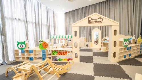 a childrens play room with a castle and swings at The Empyrean Cam Ranh Beach Resort in Cam Ranh