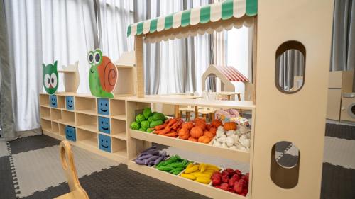 a toy kitchen with fruits and vegetables on shelves at The Empyrean Cam Ranh Beach Resort in Cam Ranh