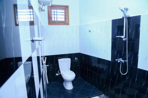 a bathroom with a toilet and a shower at Canal Side Guest House Polonnaruwa in Polonnaruwa