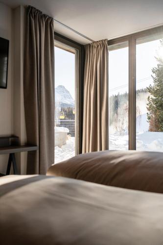 a bedroom with a bed and a large window at Surega - Idyllic Farmhouse in San Cassiano