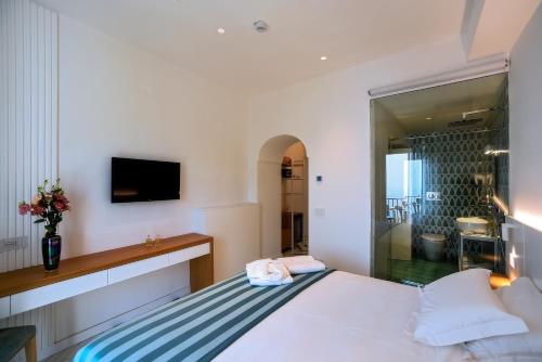 a bedroom with a bed and a tv on the wall at Hotel Graal in Ravello