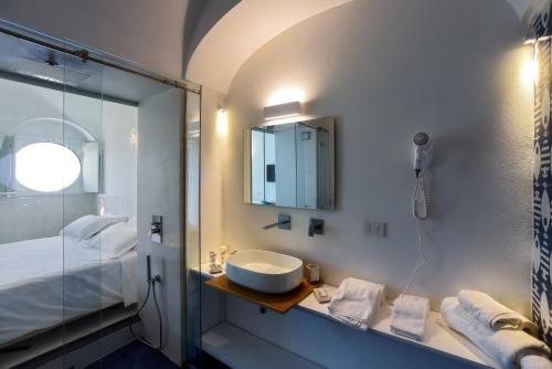 a bathroom with a sink and a glass shower at Hotel Graal in Ravello