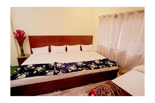 a bedroom with a bed with a floral bedspread at Rajdarshan Hotel in Ujjain