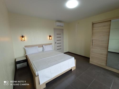 - une chambre avec un lit et une porte coulissante en verre dans l'établissement HomeHotel, à Tchornomorsk
