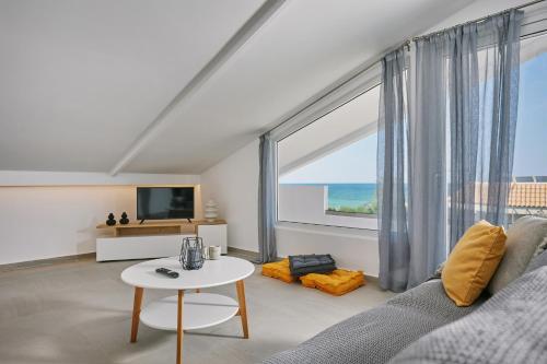 a living room with a couch and a large window at Sofita Sea View Apartment in Argassi