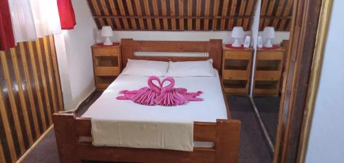 una camera da letto con un letto con un fiocco rosa di Hostel INTIM 95 RON a Bîrlad