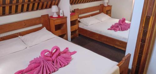 two beds in a room with pink towels on them at Hostel INTIM 95 RON in Bîrlad