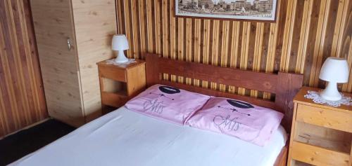a bedroom with a bed with pink sheets and two lamps at Hostel INTIM 95 RON in Bîrlad