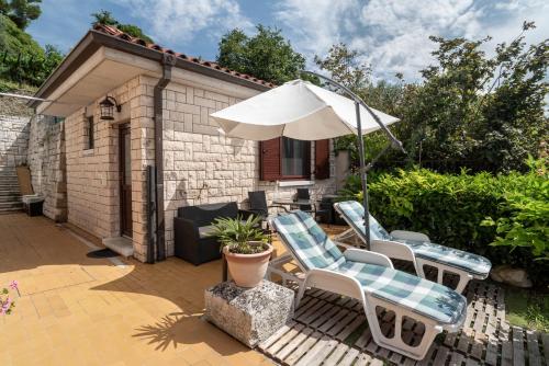 a patio with two chairs and an umbrella at Apartments Vila Toni in Portorož