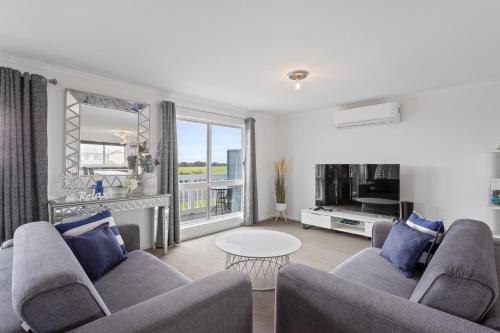 a living room with two couches and a table at Ocean Pearl by Ready Set Stay - BYO LINEN & TOWELS in Surf Beach