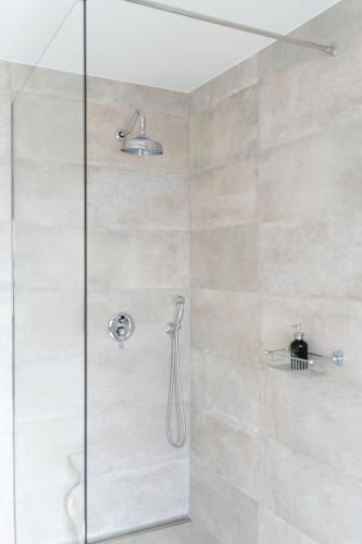 a shower with a glass door in a bathroom at Nomad Rooms in Mostar