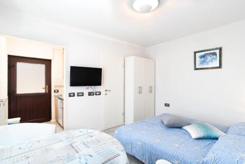 a white living room with a bed and a tv at Apartments Vila Toni in Portorož