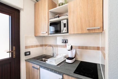 a small kitchen with a sink and a microwave at Apartments Vila Toni in Portorož