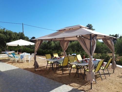 a table and chairs under a large umbrella at Fiore Di Mare Studios in Lassi