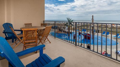 a balcony with a table and chairs and a swimming pool at Phoenix V 105 condo in Orange Beach