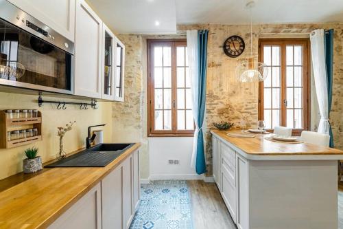 une cuisine avec des armoires blanches et un comptoir dans l'établissement L’Authentique à Marseille, à Marseille