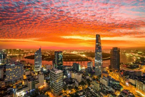 a city skyline at sunset with a red sky at Tahami Hotel Thu Duc in Ho Chi Minh City