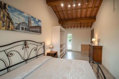 a bedroom with a bed and a wooden ceiling at Tenuta il Giardino in Capannori