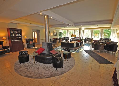 a large living room with couches and tables and windows at Hotel Alpen Residence in Ehrwald