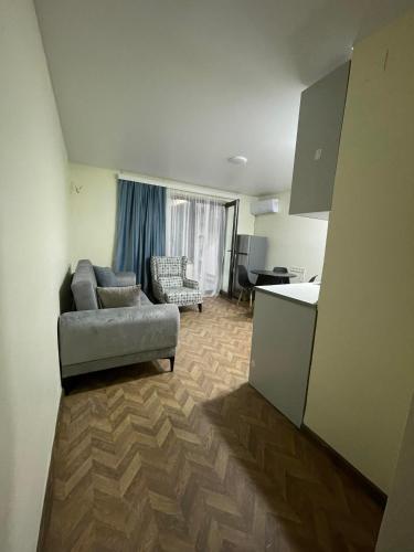 a living room with a couch and a kitchen at Flats at Era Square in Batumi