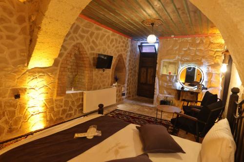 a bedroom with a bed in a stone room at Angel View Suites in Göreme