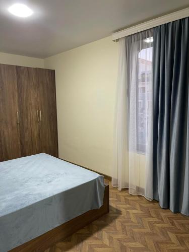 a bedroom with a bed and a window at Flats at Era Square in Batumi