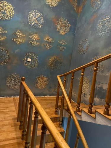 a staircase with a blue and gold wallpaper at Flats at Era Square in Batumi