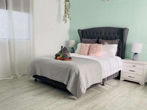 - une chambre avec un grand lit et des oreillers roses dans l'établissement Studio 69 on Capper, à Tumut