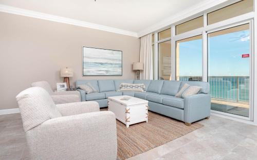 a living room with a blue couch and a chair at Phoenix Orange Beach II 1104 in Orange Beach