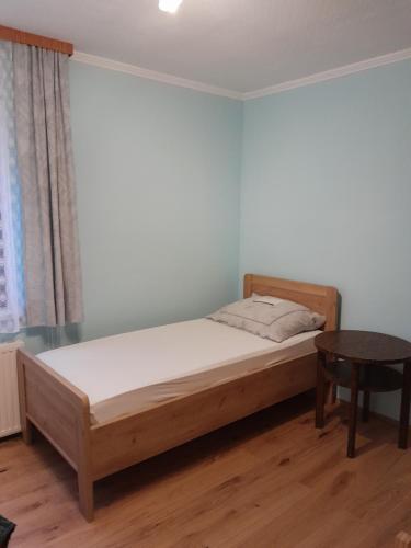 a bedroom with a bed and a table at Gästehaus M in Poysdorf