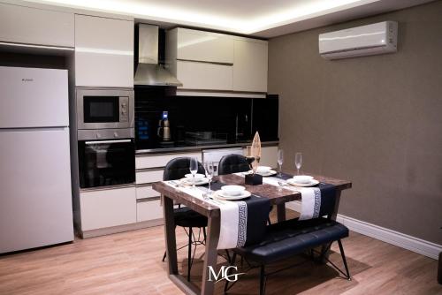 a kitchen with a table with chairs and appliances at MG HİLL RESİDENCE BUTİK OTEL in Yeşilyurt